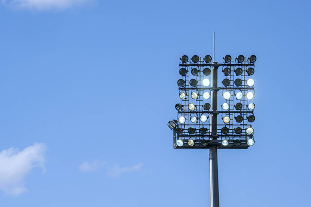 Stadyum izole mavi gökyüzü arka plan üzerinde bir projektör - Fotoğraf, Görsel