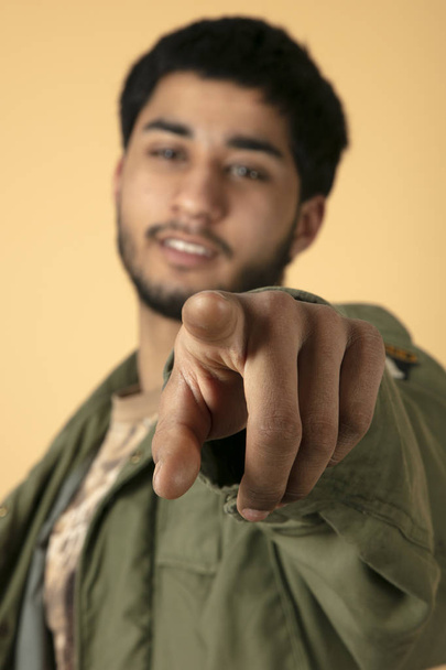 Young Man pointing with finger on beige background - Fotó, kép