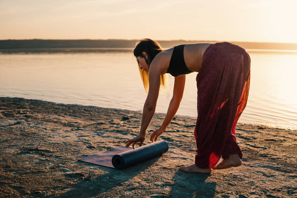 Yoga mulher na praia ao pôr do sol
. - Foto, Imagem