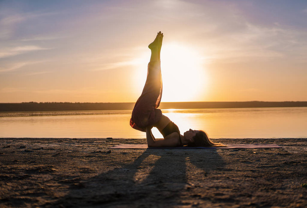 Silhouette Yoga-Frau am Strand bei Sonnenuntergang. - Foto, Bild