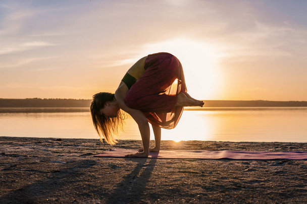 Silueta ženy jógu na pláži při západu slunce. - Fotografie, Obrázek