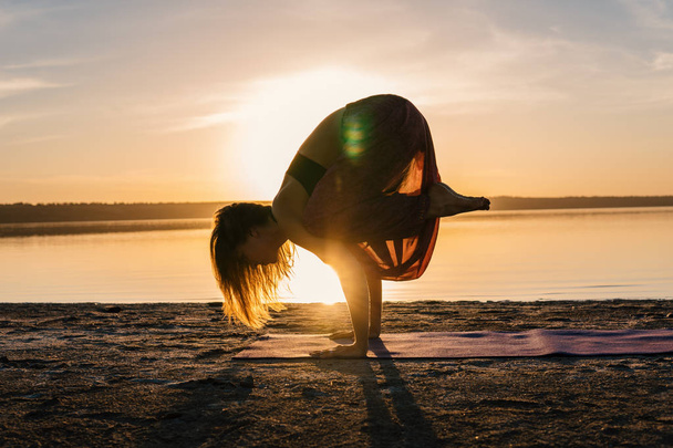 Silhouette Yoga-Frau am Strand bei Sonnenuntergang. - Foto, Bild
