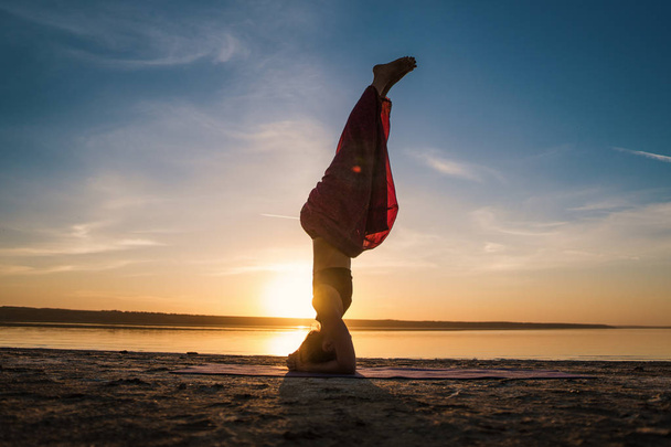 Gün batımında sahilde siluet yoga kadınla. - Fotoğraf, Görsel