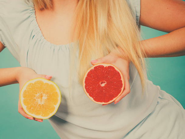 Healthy diet, refreshing food full of vitamins. Woman holding sweet delicious citrus fruit, red and green grapefruit. - Photo, image