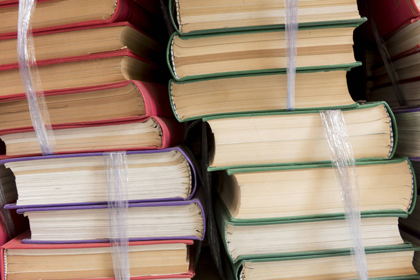 Book stack on wooden desk in library. - Fotoğraf, Görsel