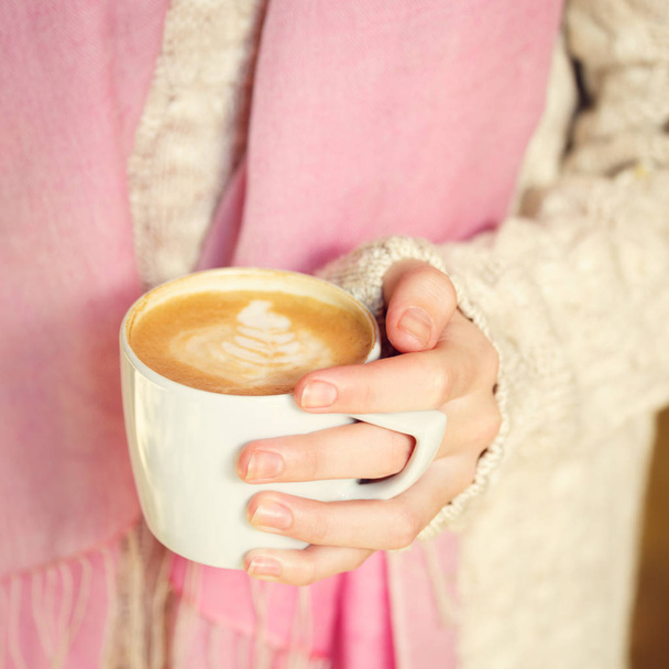 Bir fincan kahve ya da sıcak çikolata ya da chai çay latte tutan kız. Sessiz hygge zaman kavramı. Sıcak sesi. Kare - Fotoğraf, Görsel