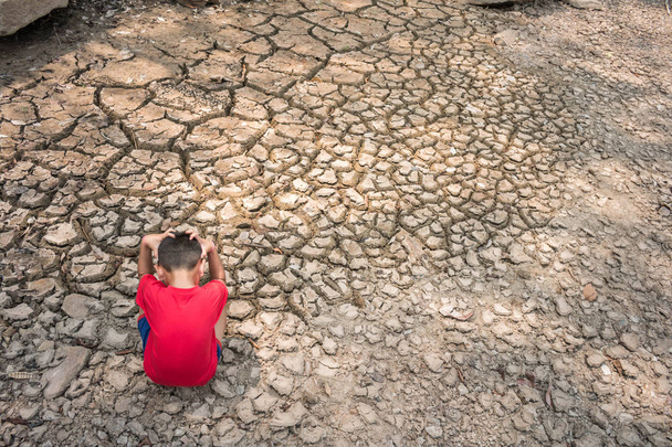 Triste un bambino su terreno asciutto, concetto di siccità
. - Foto, immagini