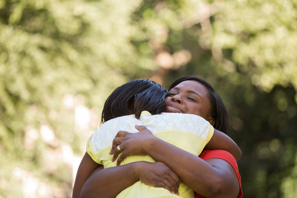 Hugghing African American matka córki. - Zdjęcie, obraz