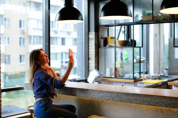 Menina encantadora fazendo selfie por smartphone no bar café
. - Foto, Imagem