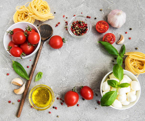 Итальянские пищевые ингредиенты - паста, помидоры на каменном фоне
 - Фото, изображение