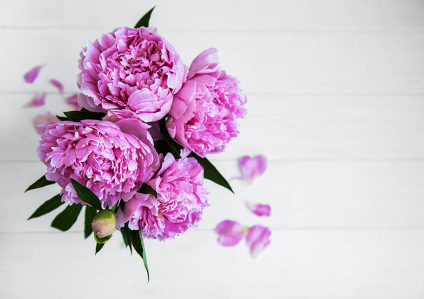 Pink peony flowers on a white wooden table - Fotoğraf, Görsel