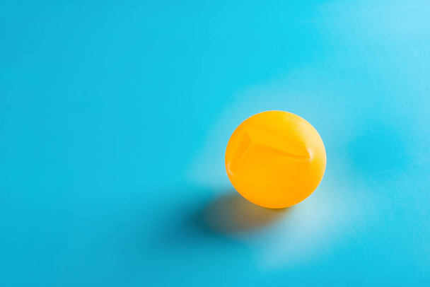 une boule de pingpong bosselée sur fond bleu
 - Photo, image