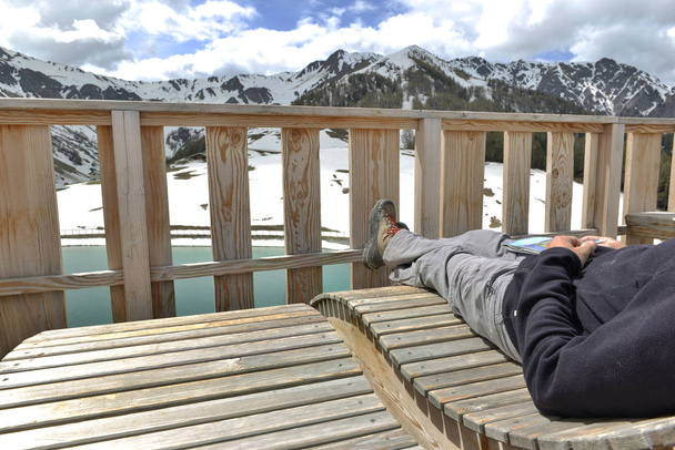 homem relaxante no terraço com vista para um lago de montanha
 - Foto, Imagem