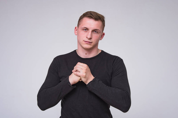 portrait of a cute young guy on a white background in different poses with different emotions. He stands directly in front of the camera and smiles - Zdjęcie, obraz