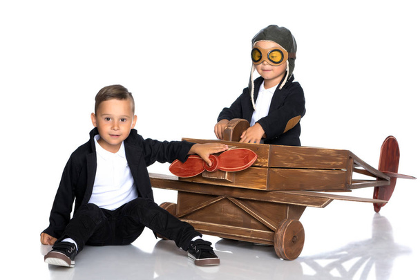 Dois meninos estão brincando com um avião de brinquedo
. - Foto, Imagem