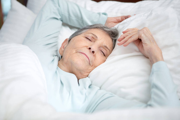 Elderly woman getting a good nights rest. - Fotoğraf, Görsel