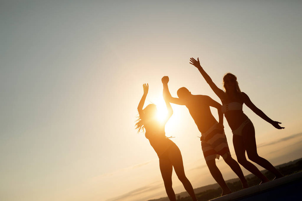 Amici che festeggiano al tramonto durante le vacanze estive
 - Foto, immagini