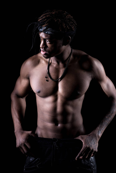 Plan studio de l'homme afro-américain musclé posant avec un fond noir
 - Photo, image