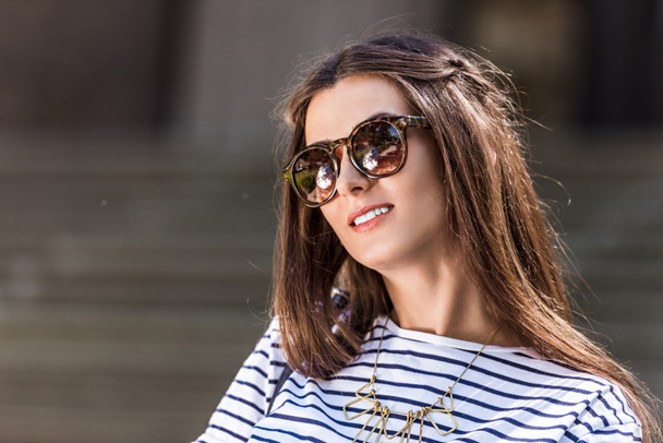 portrait of of beautiful young woman in sunglasses on street - Foto, immagini