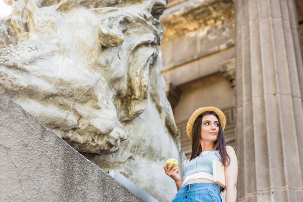 πορτρέτο των νέων κομψή γυναίκα με καπέλο με φρέσκο μήλο στην οδό - Φωτογραφία, εικόνα