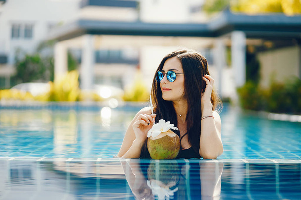 brunette girl eating fruit by the pool - Photo, image