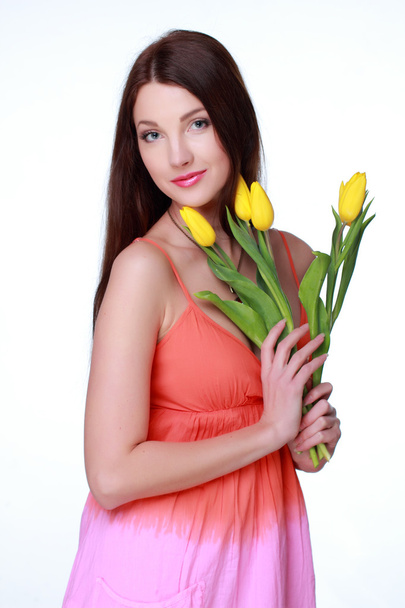 Happy girl with yellow tulips - Фото, изображение