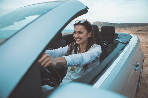 Carefree girl enjoying trip near sea by vehicle  - Foto, Bild