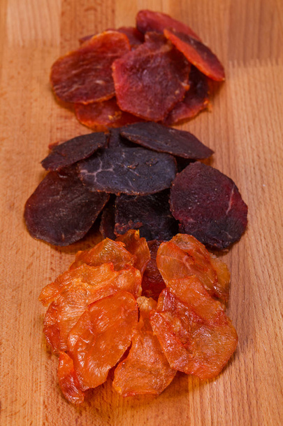 Snack de carne seca sobre el fondo de madera
 - Foto, imagen
