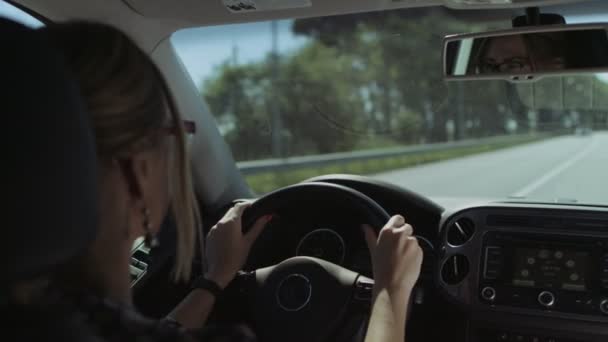 Kaunis naiskuljettaja ajaa autoa moottoritiellä
 - Materiaali, video