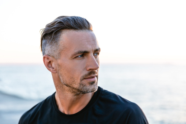 close-up portrait of handsome adult man with grey hair looking away on seashore - Photo, Image
