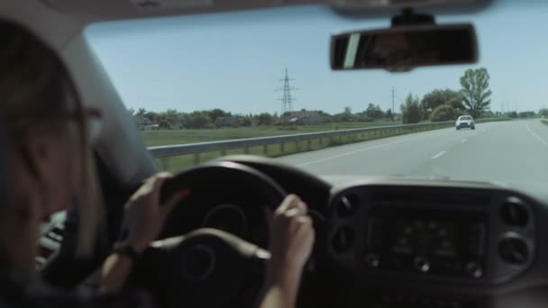 Female driver driving car on freeway on road trip - Filmagem, Vídeo