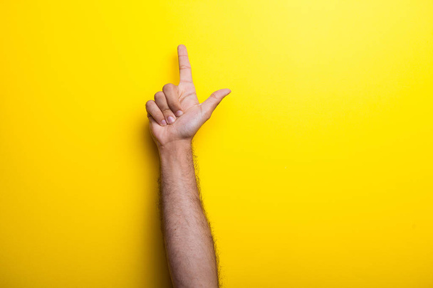 Férfi kezét felé mutat, sárga háttér - Fotó, kép