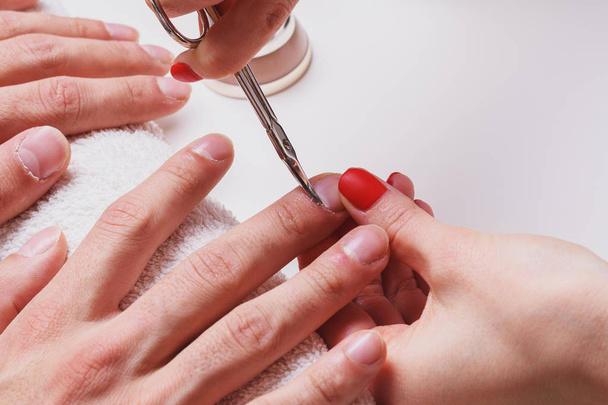 Manicura masculina. mulher esteticista trata cutículas de mãos masculinas secas
 - Foto, Imagem