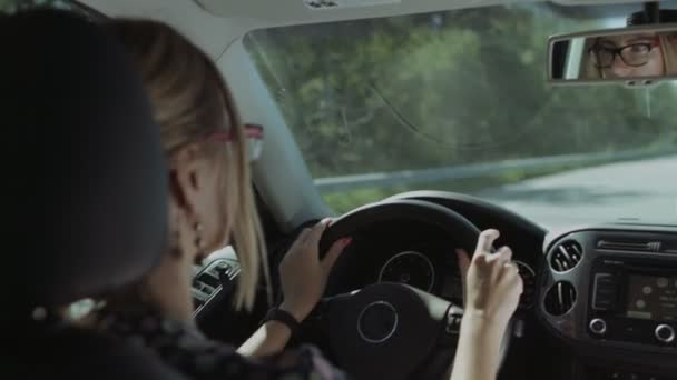 Female driver is reflected in car rear view mirror - Video, Çekim