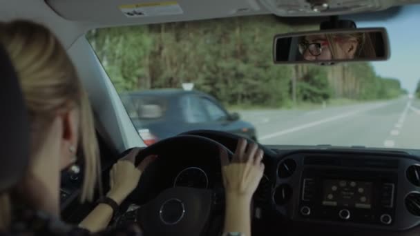 Woman driving car and making a turn on highway - Materiał filmowy, wideo