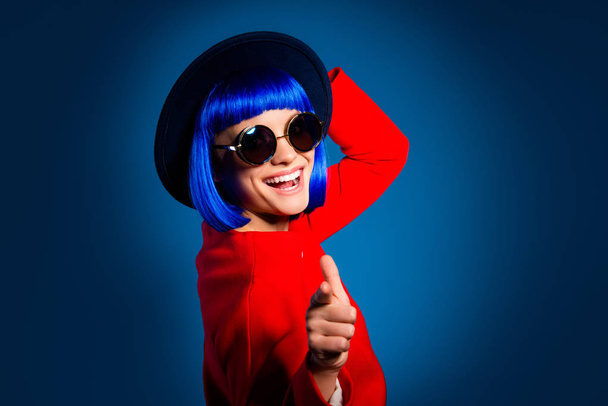 Hey you, baby! Portrait of cheerful positive girl in eyeglasses head wear pointing forefinger at camera isolated on blue background. Rest relax leisure fun weekend recreation concept - Fotoğraf, Görsel
