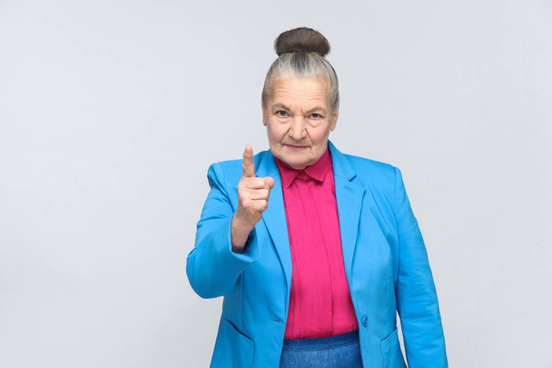 Angry aged woman looking at camera and pointing finger up while showing warning sign, Expression emotion and feelings concept    - Photo, image