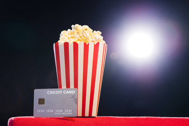 Popcorn and credit card on armchair cinema - Fotó, kép