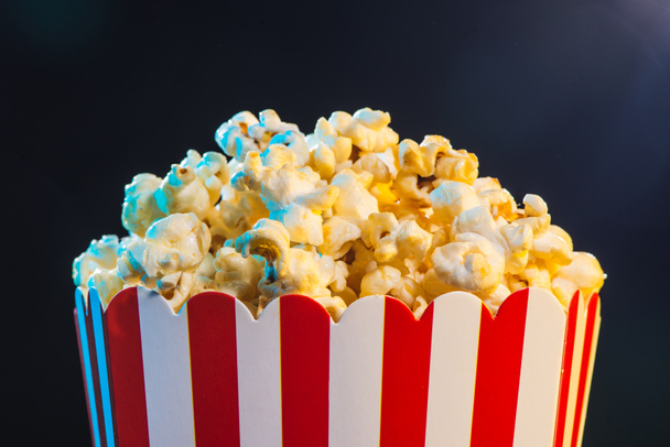 Popcorn over cinema light background, movie concept - Photo, Image