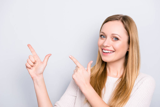 Head shot portrait of trendy stylish girl gesturing copyspace empty place with two forefingers looking at camera isolated on grey background - Zdjęcie, obraz