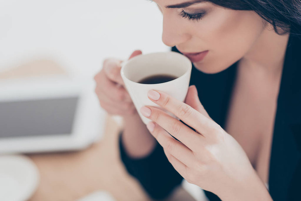 Close up cropped portrait of dreamy lovely woman  drinking coffee holding cup enjoying aroma having pleasure. Recreation idyllic delight concept - Foto, imagen