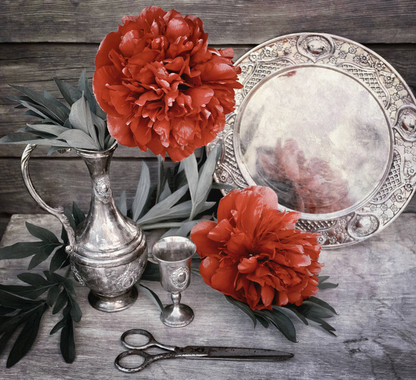 La peonía roja en una jarra de metal cuesta sobre el fondo de una pared de madera. El verano y la primavera florecen escena
. - Foto, imagen