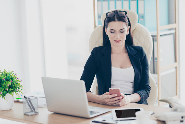 Cropped portrait of trendy stylish woman holding smart phone having rest time out chatting with friends checking email using wifi 5G internet sitting at desk in workstation - Fotoğraf, Görsel