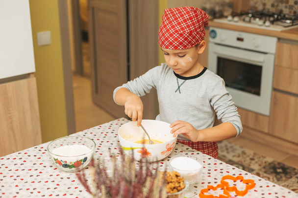 Симпатичний хлопчик готує на кухні вдома
  - Фото, зображення