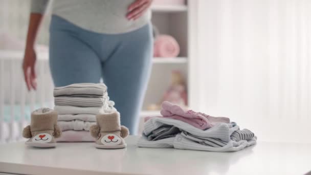 Schwangere sortiert Babykleidung aus - Filmmaterial, Video