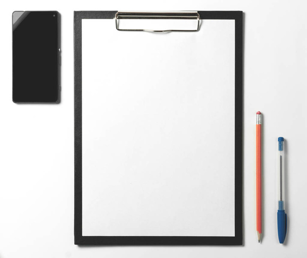 Lege Klembord, smartphone, pen en potlood op witte achtergrond. Bedrijfsconcept - Foto, afbeelding