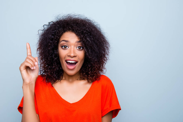 Portrait of amazed funny woman with modern hairdo in vivid outfit gesturing forefinger up with wide open mouth eyes having good idea isolated on grey background - Foto, Imagen