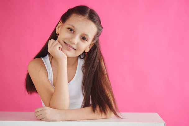 smiling girl model in white tank top posing on pink background  - Zdjęcie, obraz