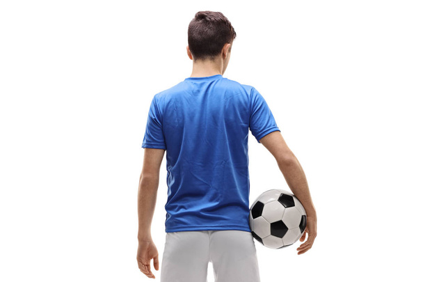 Hátsó nézet szemcsésedik-ból egy tizenéves futballista gazdaság egy labdarúgó elszigetelt fehér background - Fotó, kép