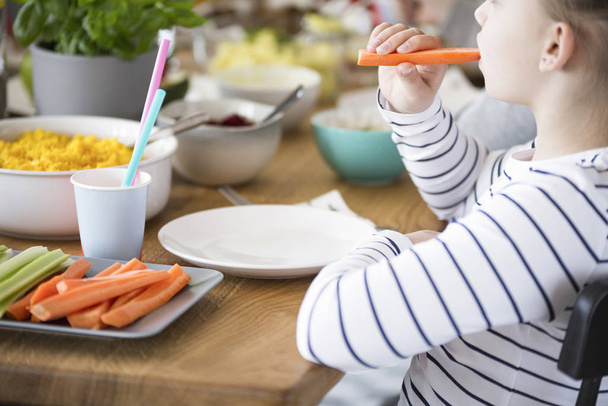 Close-up of kid eating carrot during breakfast. Healthy diet for child concept - Foto, Imagem